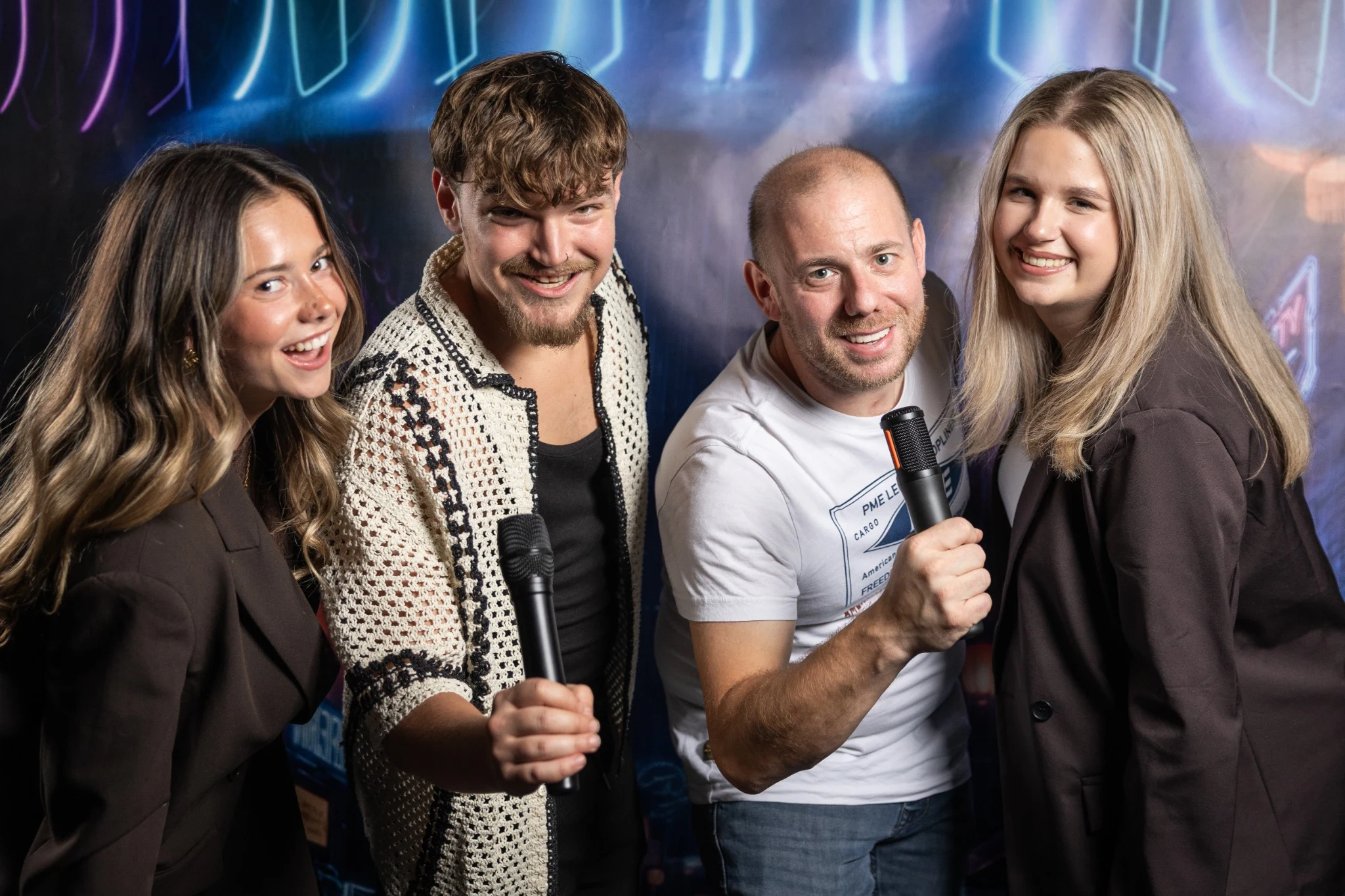Vier bezoekers met microfoons in de SING! karaokeruimte